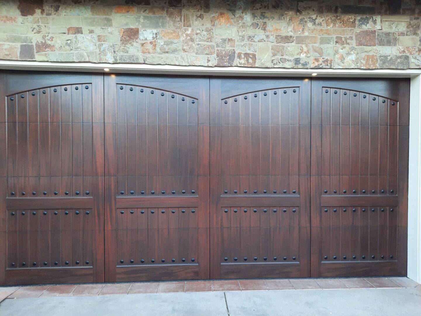 A wooden garage door with a metal handle.