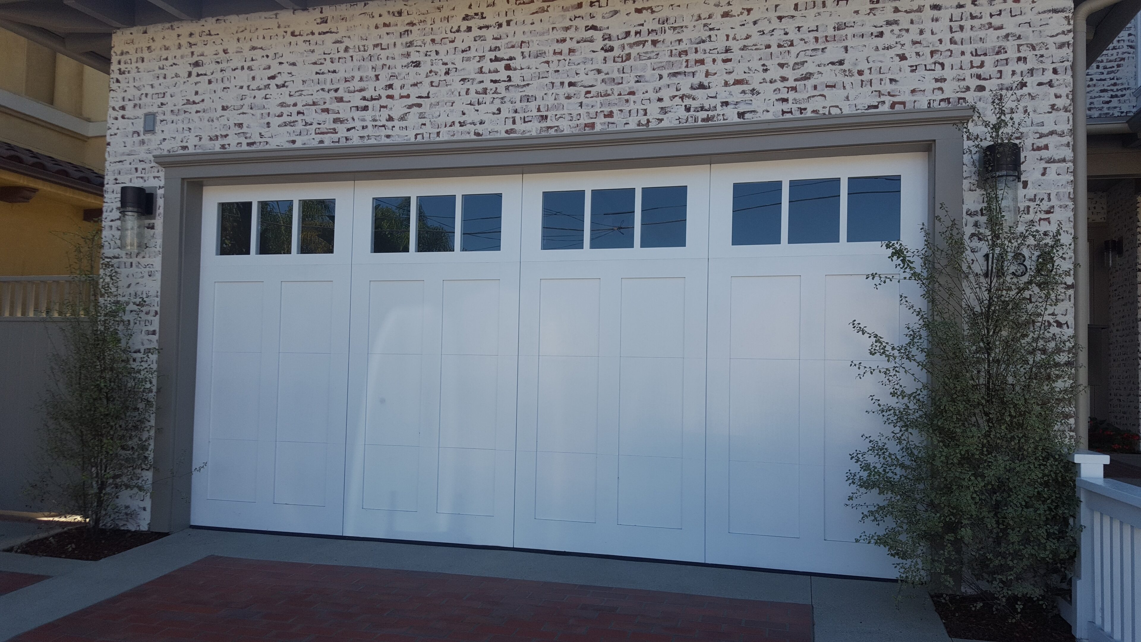 A white garage door with windows on the side of it.