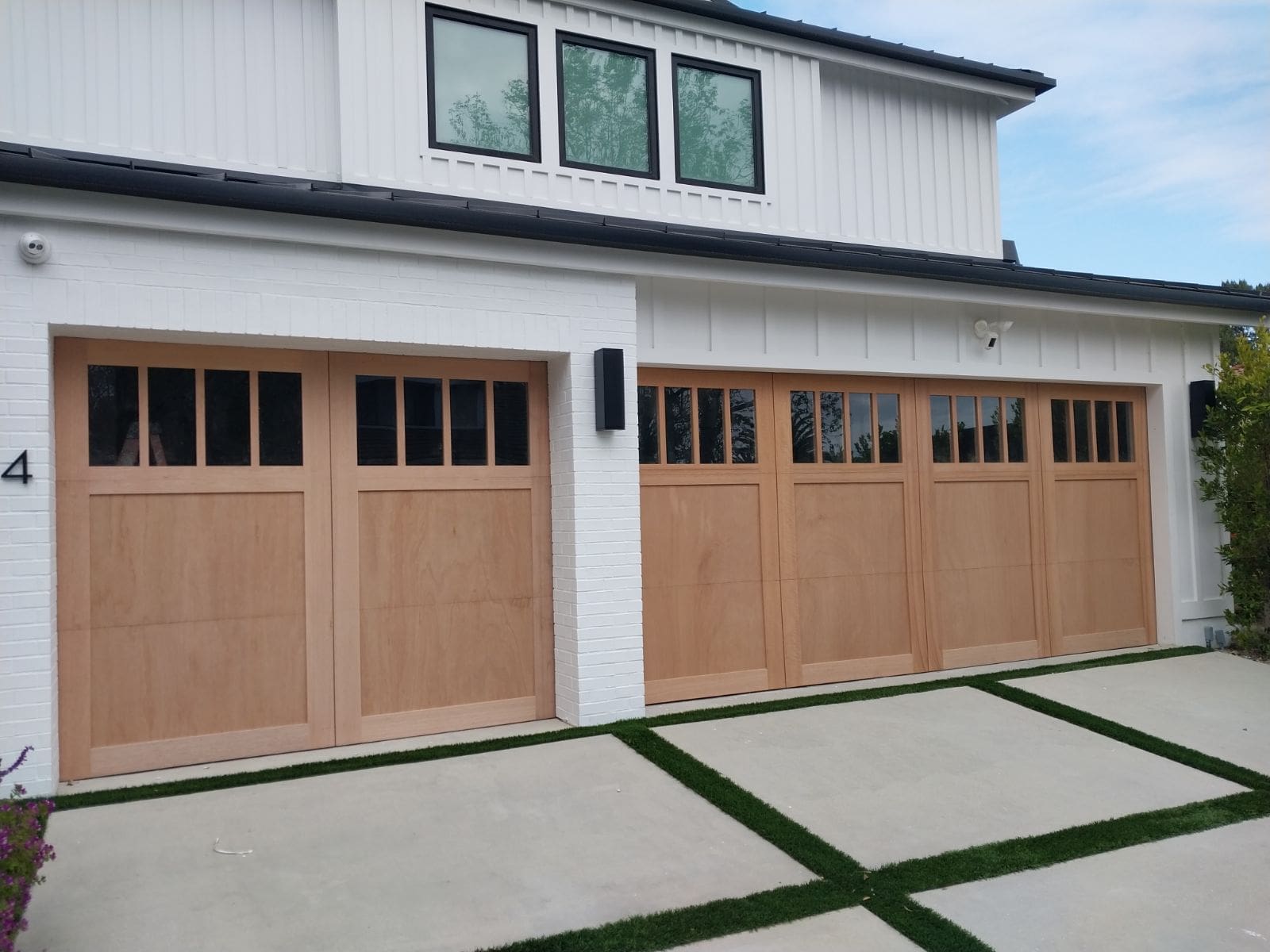 A white house with two wooden garage doors.